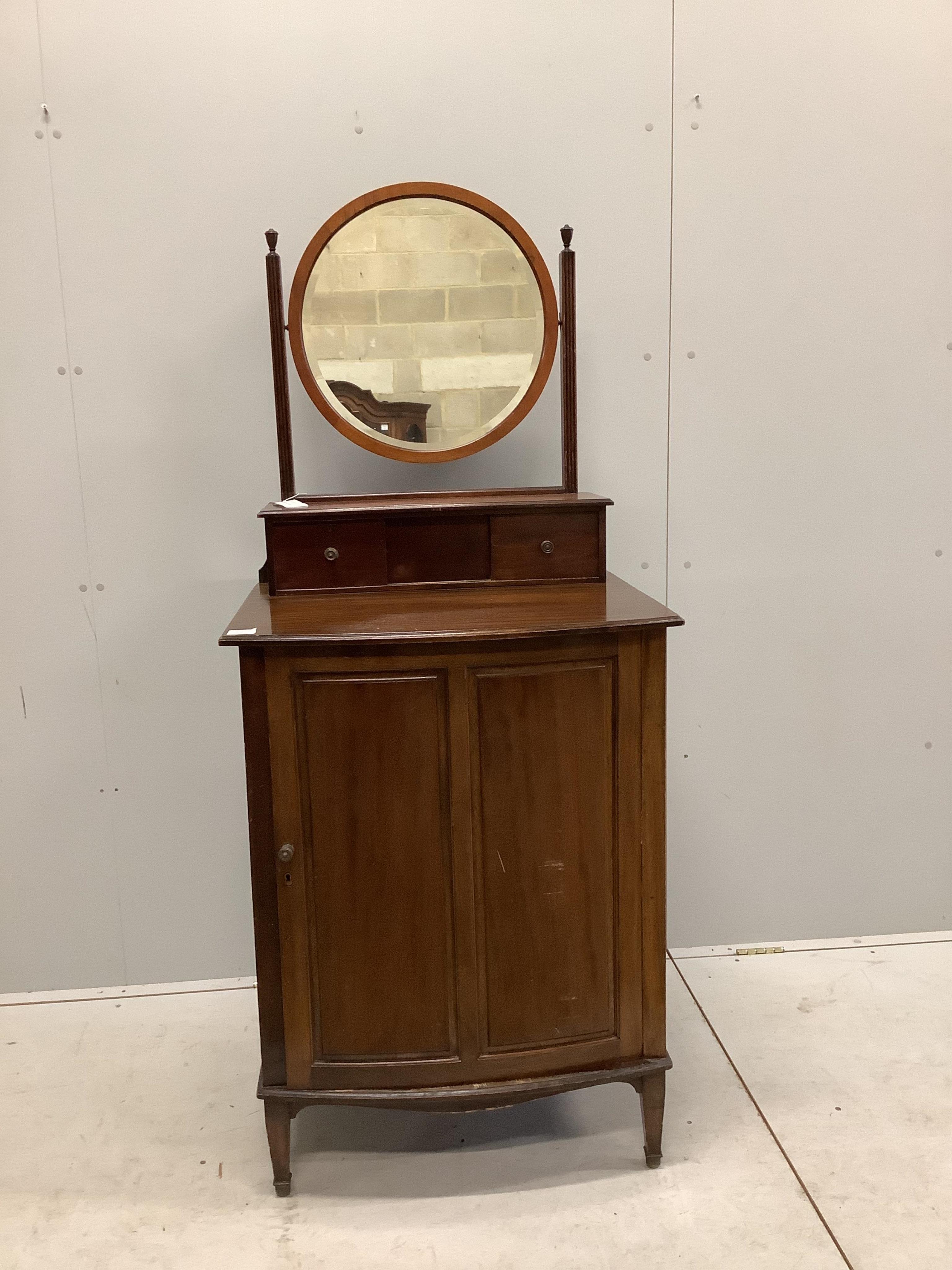 An early 20th century mahogany bowfront dressing chest, with bevelled plate circular mirror, and panelled cupboard base, width 68cm, depth 58cm, height 158cm. Condition - fair